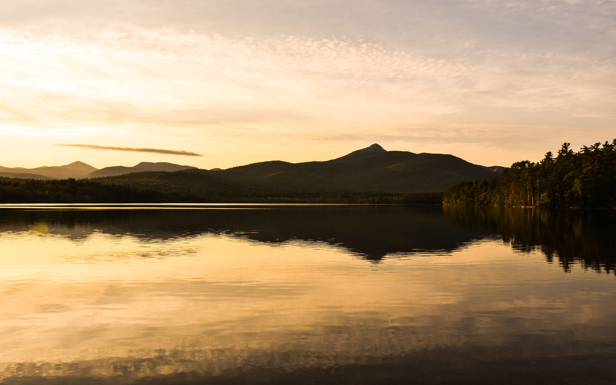 Golden evening light over the lake, hills reflected in still water