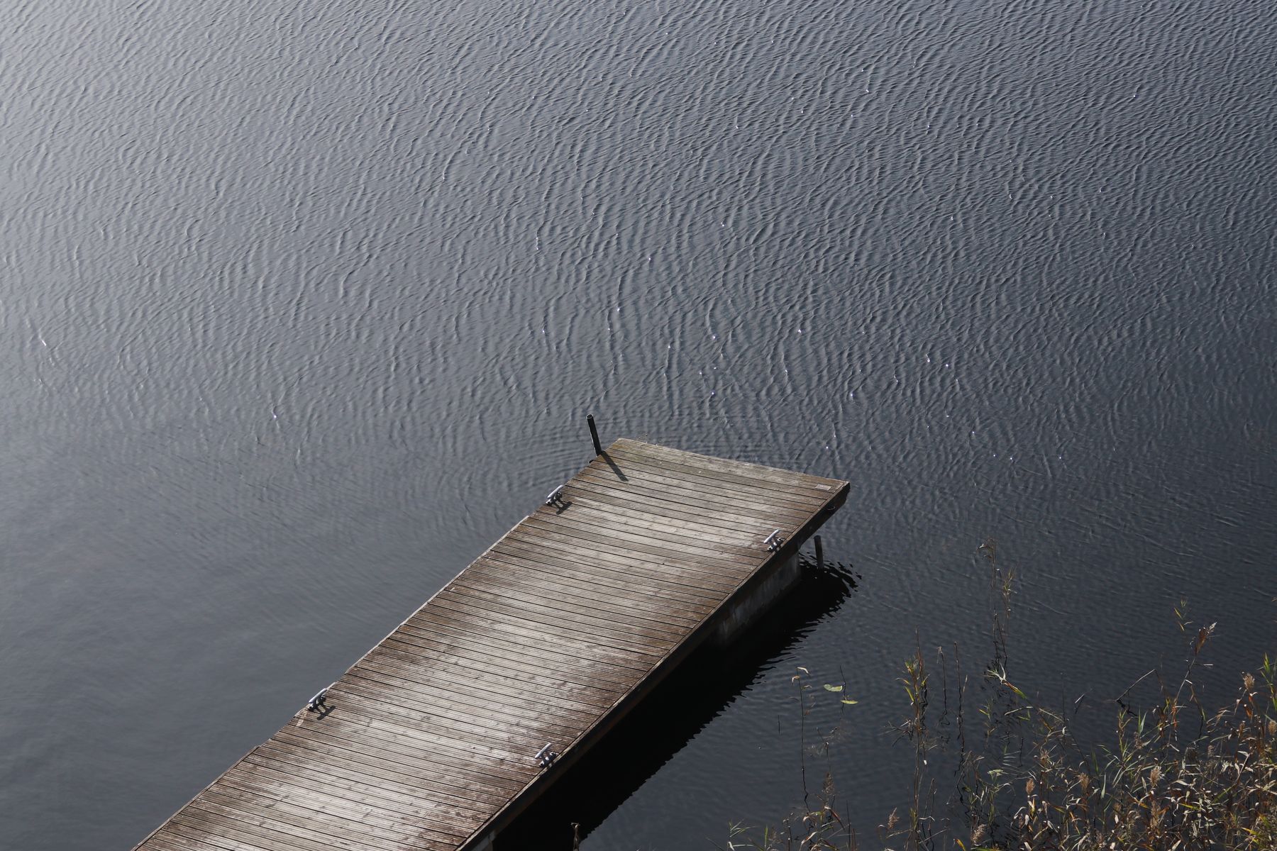 An old wooden pier reaching into still water